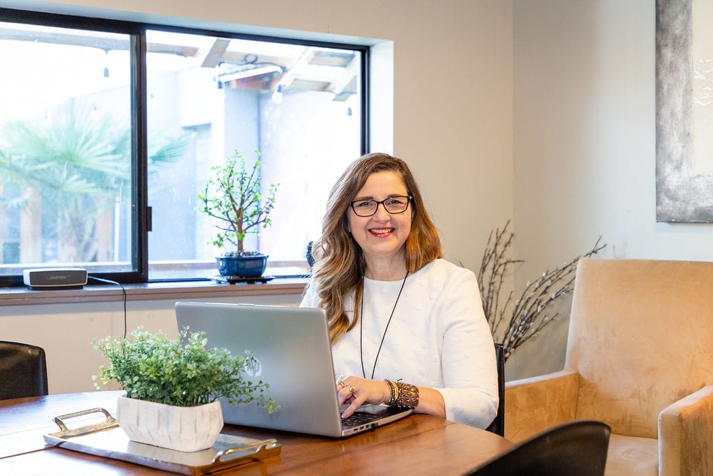 Broker Kim Pelham reviewing offers on a laptop
