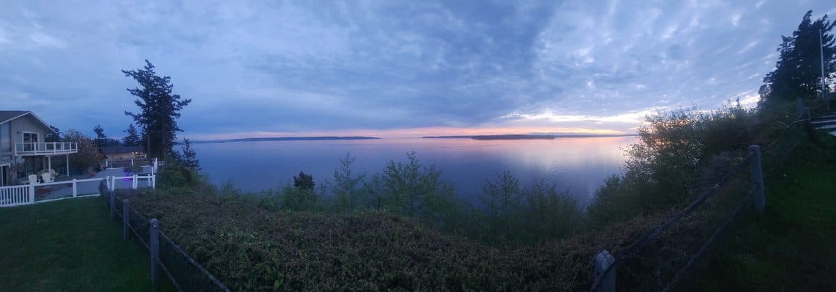 Panoramic sunset over Puget Sound from the deck at 1406 Potlatch Beach Road — house edge visible left