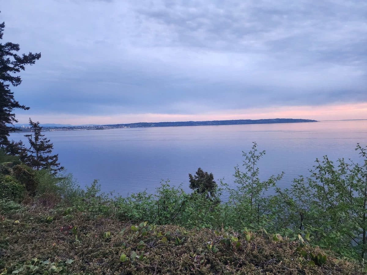 Pastel evening sky over Puget Sound with distant city lights