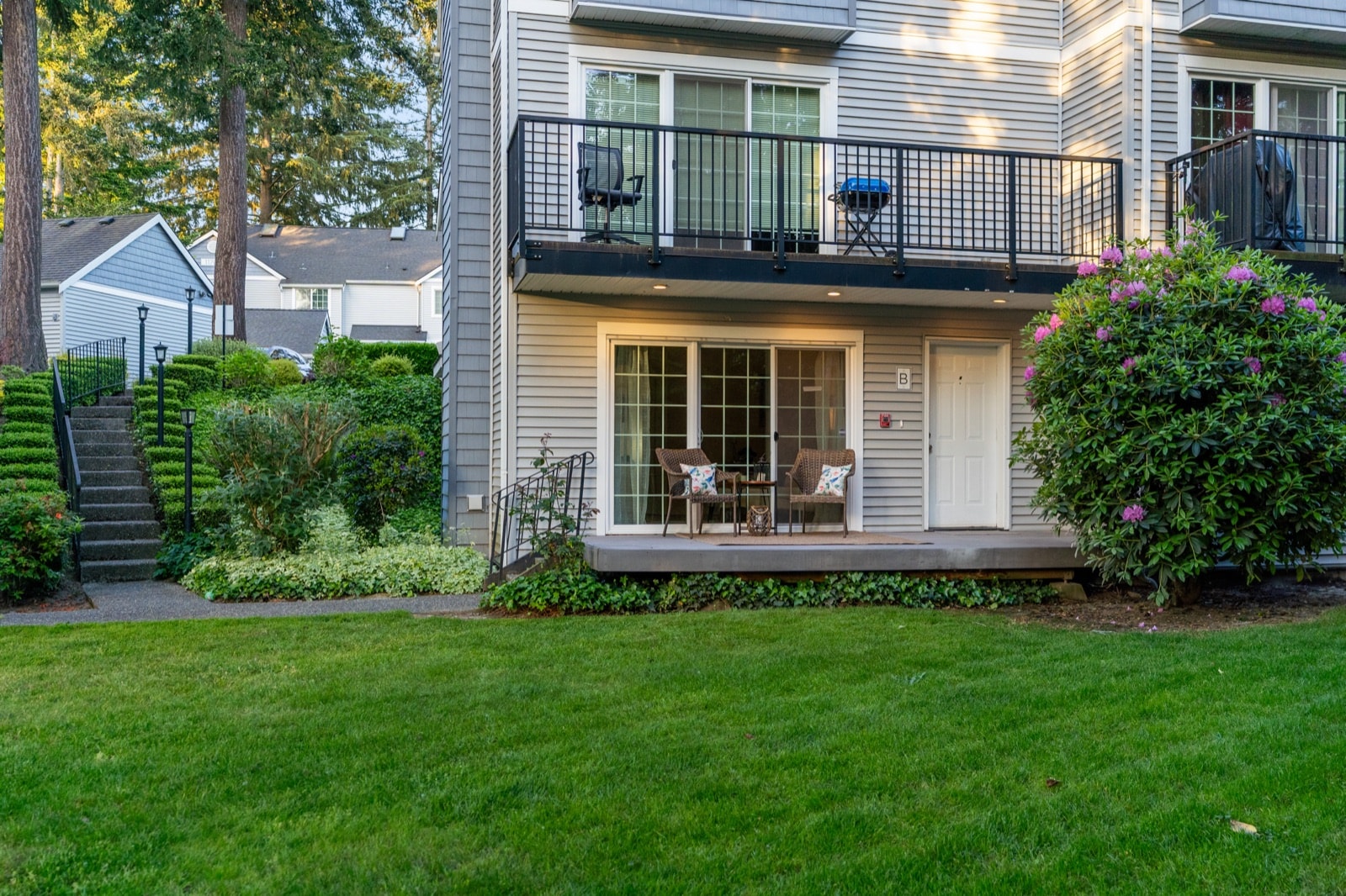 Back exterior of 11706 Admiralty Way Unit B, Everett WA, ground-floor end-unit condo with private patio and lawn