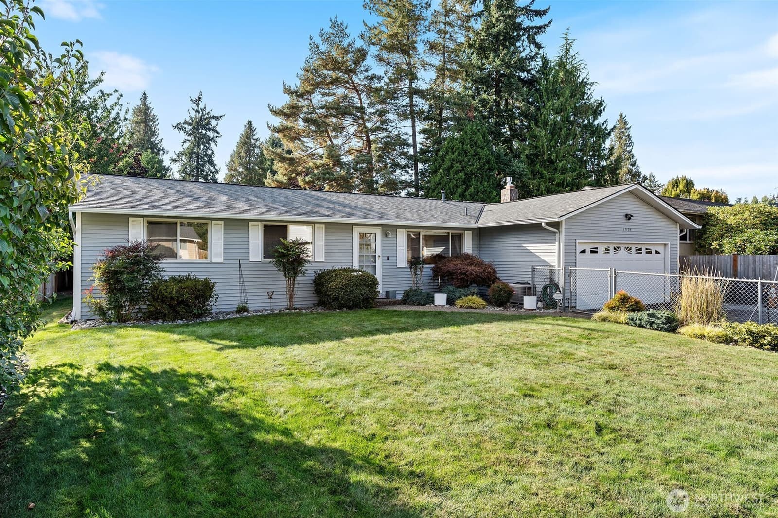 Front of the single-level rambler with a wide flat lawn at 17104 24th Ave SE, Bothell WA